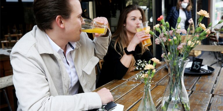 Die Mülheimer Alina (r) und Mats trinken seit Ewigkeiten zum ersten Mal wieder im Außenbereich eines Cafés in der Innenstadt ihre Getränke. Mülheim gehört zu den Städten in Nordrhein-Westfalen, die die Außengastronomie unter bestimmten Auflagen wieder erlauben.