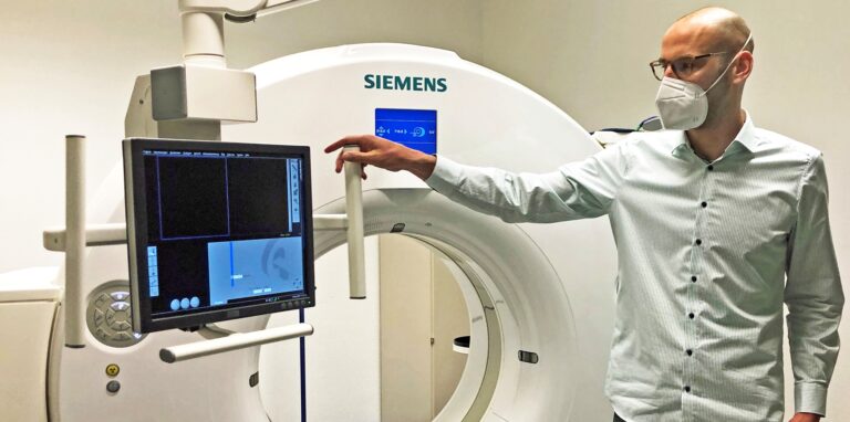 Arne Scheffer zeigt das moderne CT, das auch in der Covid-Diagnostik eingesetzt wird.