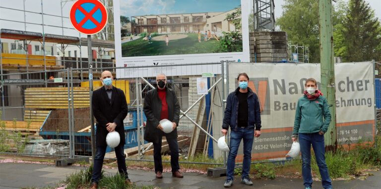 Vor der Kita-Baustelle an der Annastraße stehen (v.l.) Sebastian Scholz (Leiter des städtischen Immobilienbetriebs HIB), Bürgermeister Matthias Müller und Architekt Carsten Barkmann (HIB) und Maike Stiel (Geschäftsführerin der Falkennest Kita gGmbH).