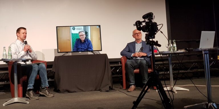Mit dem NRW-Landesvorsitzenden der Gewerkschaft der Polizei, Michael Mertens (auf dem Bildschirm), sprechen der SPD-Kreistagsabgeordnete Dr. Frank Lelke (l.) und der SPD-Landtagsabgeordnete Carsten Löcker per Videokonferenz aus der Schwarzkaue Schlägel & Eisen über Digitalisierung und innere Sicherheit.