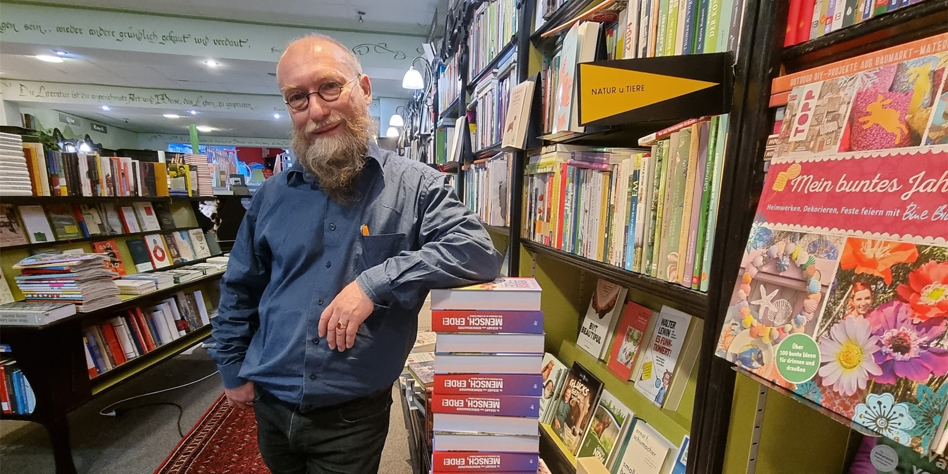 Buchhändler lehnend an Büchern