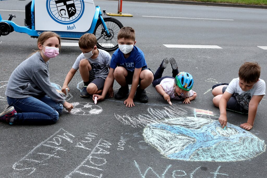 Vor dem Start malten Kinder bunte Motive zum Weltfahrradtag auf den Asphalt.