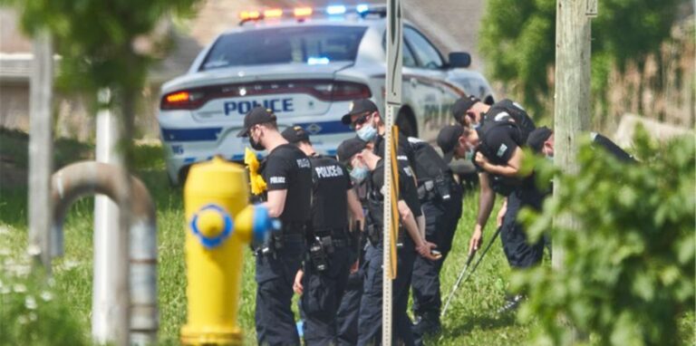 Polizisten in Reihe untersuchen den Tatort eines Autounfalls in London, Ontario. Nach einem Angriff mit einem Auto, bei dem vier Menschen aus einer muslimischen Familie getötet worden sind, geht die Polizei Berichten zufolge von einem rassistischen Tatmotiv aus.