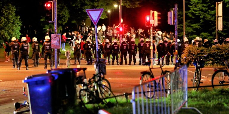 Die Polizei geht auf einer Wiese am Aasee gegen Randalierer vor. Nachdem Kontrollen der Stadt zunächst Wirkung gezeigt und Hunderte Besucher friedlich gefeiert hatten, sei die Situation im Laufe der Nacht eskaliert.