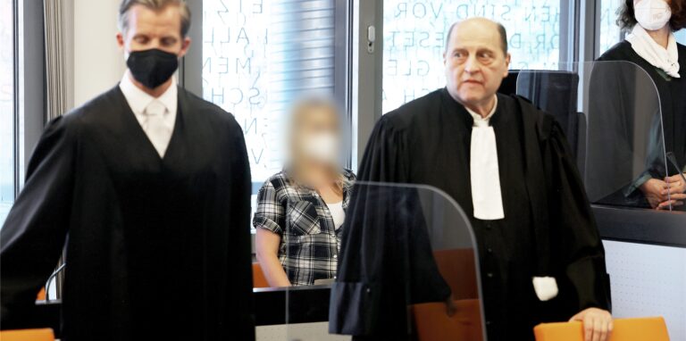 Die angeklagte Mutter (M) steht zwischen ihren Anwälten Felix Menke (l) und Thomas Seifert (r) im Gerichtssaal. Im Fall der fünf getöteten Kinder im nordrhein-westfälischen Solingen hat vor dem Landgericht Wuppertal der Mordprozess gegen deren Mutter begonnen.