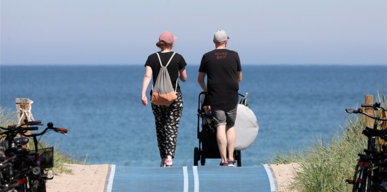 Urlauber gehen an den Ostseestrand, um das Sommerwetter zu genießen.
