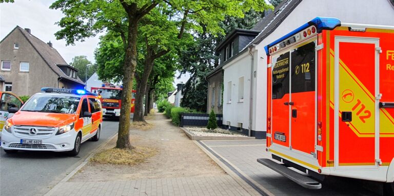 Rettungswagen, Notarzt und ein Löschfahrzeug der Feuerwehr stehen auf der Siedlungsstraße.