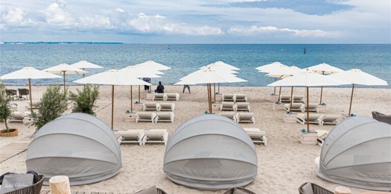 Strandliegen und Sonnenschirme stehen in Timmendorfer-Strand für Badegäste bereit.