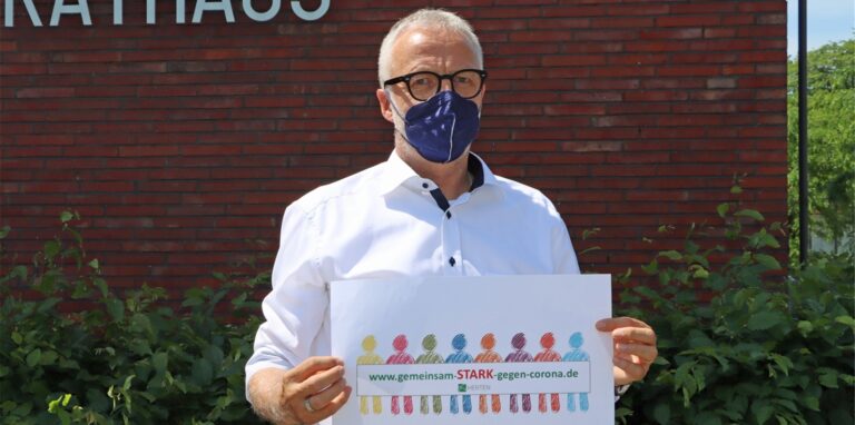 Bürgermeister Matthias Müller zeigt das Logo der Kampagne „Gemeinsam stark gegen Corona“.