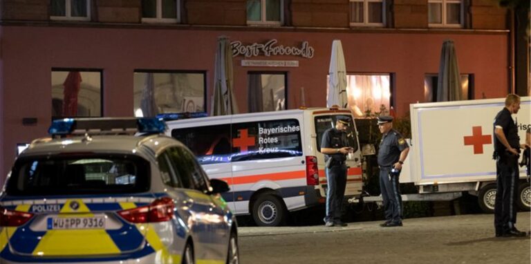 Einsatzfahrzeuge stehen nahe des Tatorts auf dem Barbarossaplatz in der Innenstadt von Würzburg. Foto: Daniel Karmann/dpa