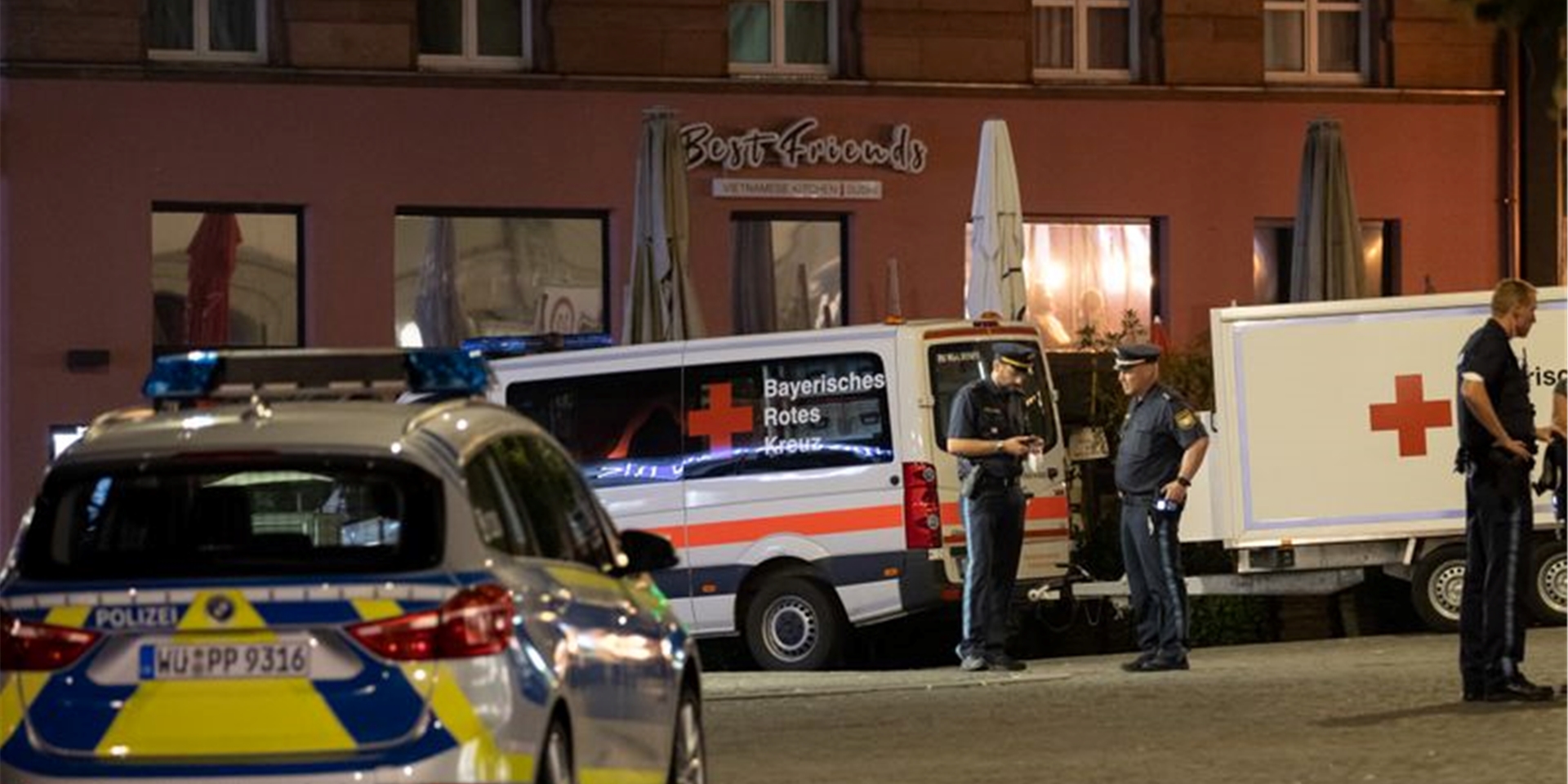 Einsatzfahrzeuge stehen nahe des Tatorts auf dem Barbarossaplatz in der Innenstadt von Würzburg. Foto: Daniel Karmann/dpa