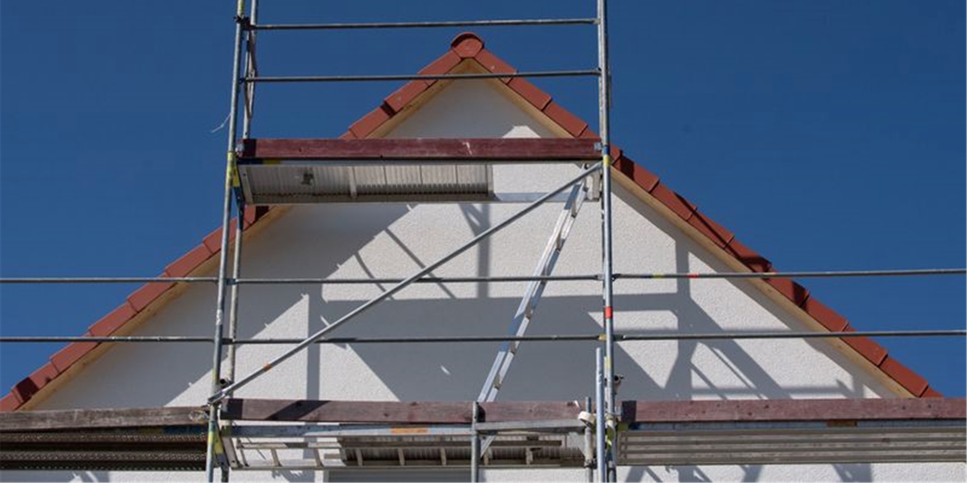 Gerüste stehen an einem Haus einer Neubausiedlung im Frankfurter Stadtteil Nieder-Erlenbach. Foto: Boris Roessler/dpa