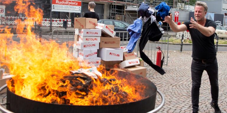 Fernsehjournalist Jenke von Wilmsdorff wirft Altkleidung in ein Feuer auf dem Rudolfplatz. Der Reporter dreht gerade wieder eine Reportage für der Sender ProSieben, die am 31. August ausgestrahlt wird.
