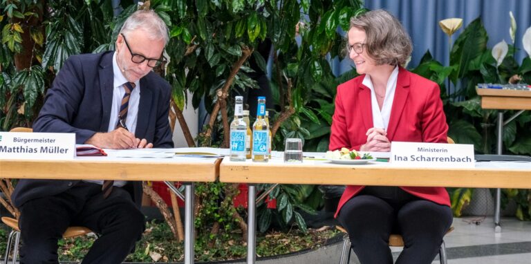 Premiere für den Bürgermeister: Matthias Müller unterschreibt den ersten von zwei Förderbescheiden, die NRW-Bauministerin Ina Scharrenbach aus Düsseldorf mitgebracht hat.