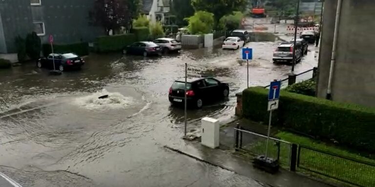 Der Danziger Ring steht unter Wasser. Ein Auto fährt über die überschwemmte Straße in Herten.