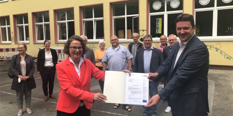 Ministerin Ina Scharrenbach und Bürgermeister Rajko Kravanja mit Vertretern aus Rat, Verwaltung und des Bürgervereins bei der Übergabe des Förderbescheids.
