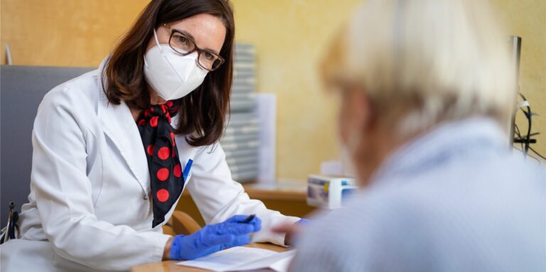 Eine Fachärztin für Allgemeinmedizin, spricht in ihrer Praxis mit einer Patientin, die wenig später ihre zweite Corona-Impfung erhält.