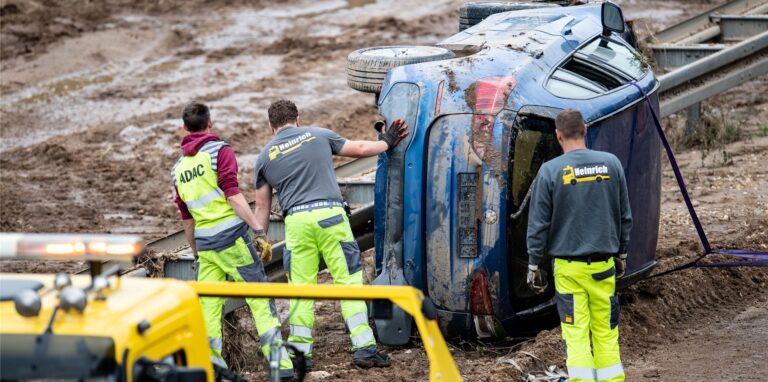 Helfer bergen nach dem Unwetter die Autos in Erftstadt.