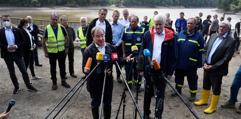 Bundesinnenminister Horst Seehofer (CSU, r) und der Ministerpräsident von Nordrhein-Westfalen, Armin Laschet (CDU, l) sprechen vor der Steinbachtalsperre zu den Medien. Die Dämme der Talsperre drohten wegen dem Hochwasser tagelang zu brechen.