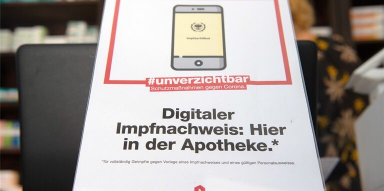 Ein Schild mit dem Aufdruck „Digitaler Impfnachweis: Hier in der Apotheke“ steht in einer Apotheke. Aktuell ist dieser Service nicht mehr möglich.