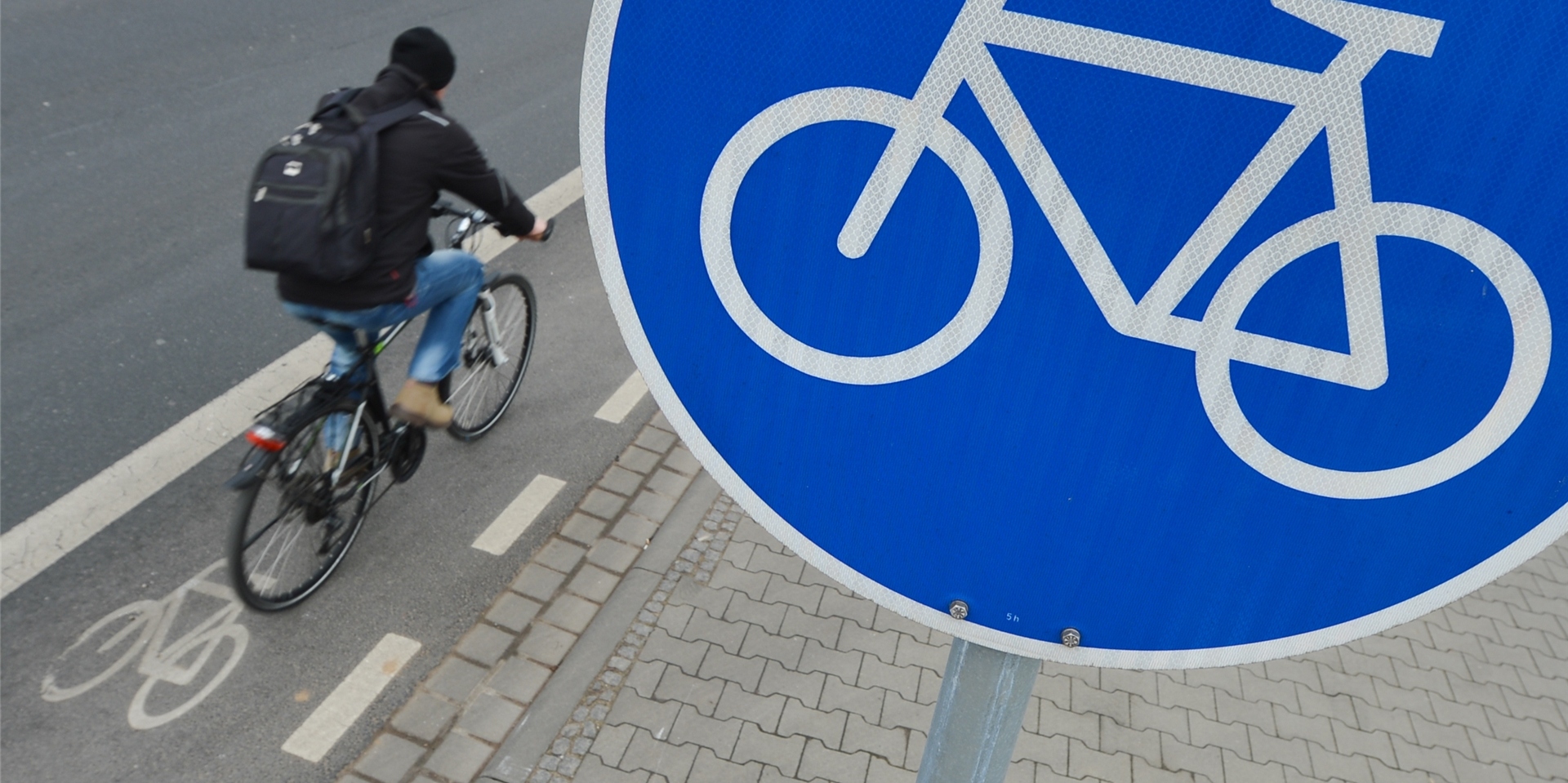 Ein Radfahrer und ein Radwegschild.