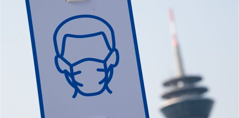 Ein Piktogramm weist in Düsseldorf auf das Einhalten der Maskenpflicht hin.