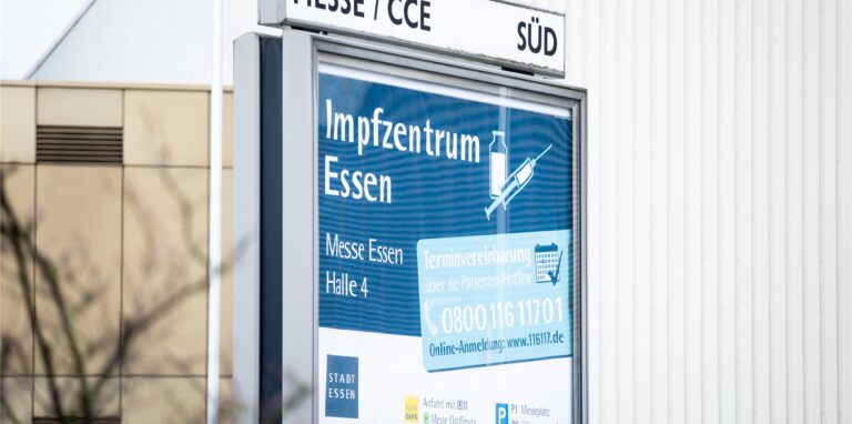 Ein Schild weist auf das Impfzentrum in der Messe Essen hin.