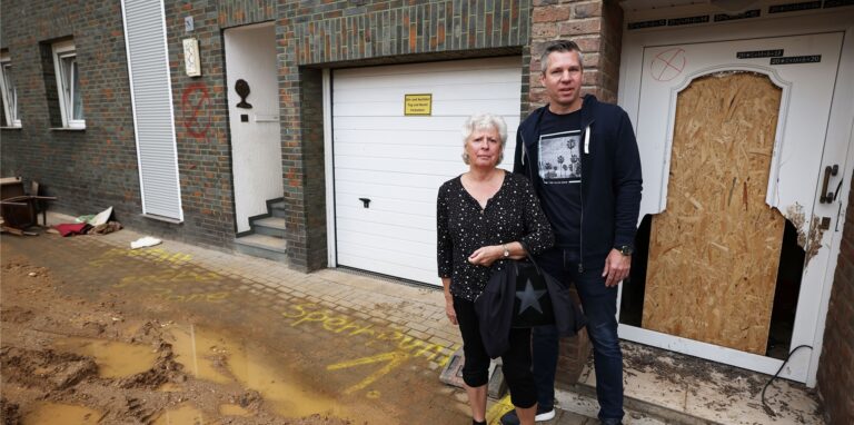 Maria Dunkel und ihr Sohn Thomas stehen vor ihrem Haus in Erftstadt-Blessem an der Rademacherstraße. In Erftstadt tat sich in der Nacht zum 15. Juli die Erde auf und verschlang mehrere Häuser. Maria und Ulrich Dunkel bangten damals um ihr Leben. Letztlich blieb ihr Haus verschont – aber dort wieder einziehen wollen sie unter keinen Umständen.