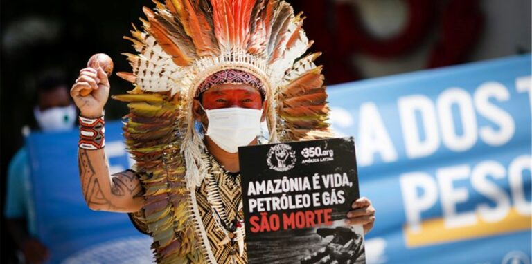 Ninawa Inu Huni kui hält ein Schild mit der Aufschrift „Amazonen ist Leben, Öl und Gas sind Tod“ während eines Protests gegen Auktionen zur Erkundung von Ölfeldern in den Amazonen vor einem Hotel in Rio de Janeiro.