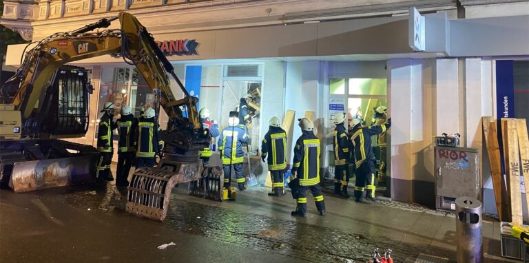 Feuerwehrleute stehen vor einem Haus, in dem mehere Geschossdecken eingesackt sind.