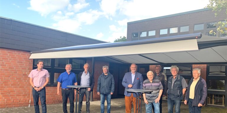 Pfarrer Karl Henschel (2.v.l.) und Glieder der evangelischen Gemeinde freuen sich über eine große Markise, die den Vorplatz des Gemeindezentrums weit überspannt.