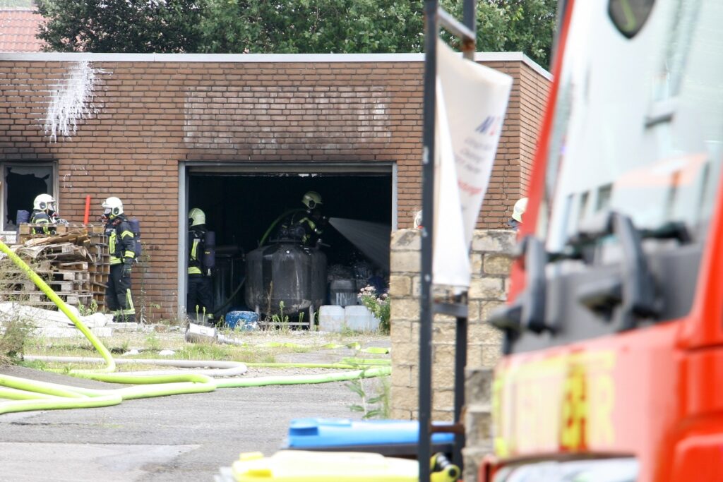 title attribut Einsatzkräfte löschen in einer Garage, in der sich auch ein großer Tank mit einem nicht bekannten Inhalt befindet.
