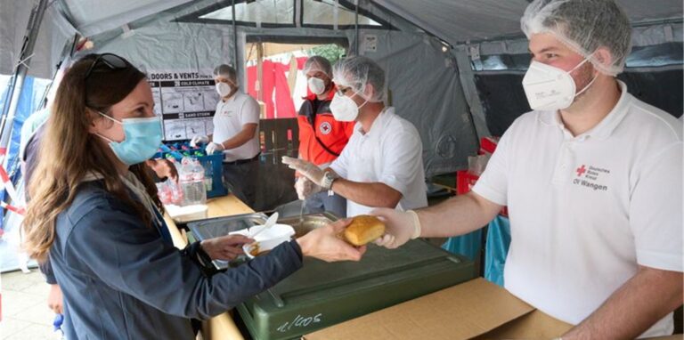 Helfer vom Roten Kreuz geben in Ahrweiler Essen aus. Dreimal täglich werden mehr als 10000 Mahlzeiten für die Opfer der Flutkatastrophe und die zahlreichen Helfer zubereitet.