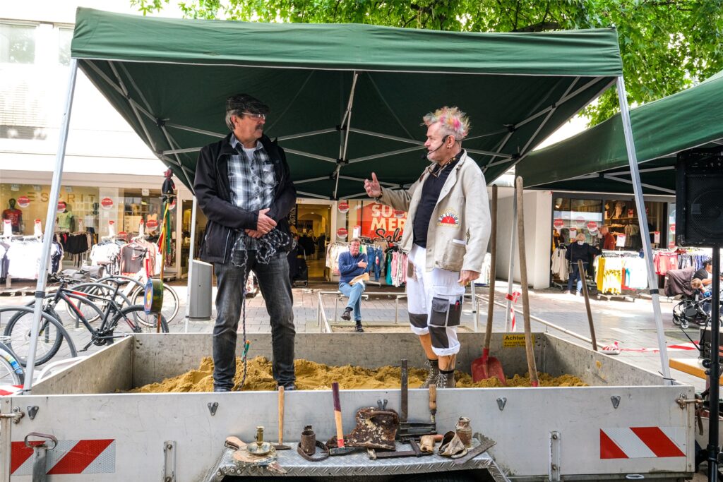 Andreas Dickel (links), seines Zeichens pensionierter Kriminalist, hat seinen Hund Bella mitgebracht. Das Tier hat einen seltsamen Fund gemacht. Baustellen-Chef Punky (rechts) rätselt, was das wohl bedeuten könnte.