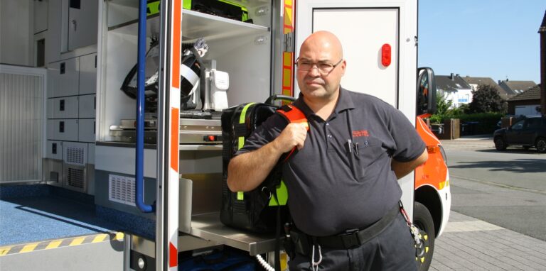 Alle wichtigen medizinischen Geräte, die an der Einsatzstelle benötigt werden, lassen sich jetzt durch eine Außenklappe aus dem Rettungswagen entnehmen. Der schwere Notfall-Rucksack lagert auf einer ausziehbaren Platte in Rückenhöhe, kann also – wie hier von Antonio Morcillo – ergonomisch aufgesetzt werden. Die EKG-Einheit mit Defibrillator ist zusätzlich auch von innen zu bedienen.