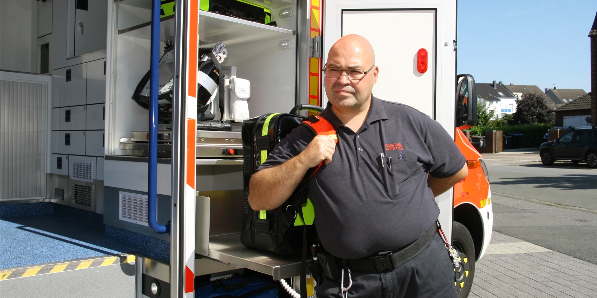 Alle wichtigen medizinischen Geräte, die an der Einsatzstelle benötigt werden, lassen sich jetzt durch eine Außenklappe aus dem Rettungswagen entnehmen. Der schwere Notfall-Rucksack lagert auf einer ausziehbaren Platte in Rückenhöhe, kann also – wie hier von Antonio Morcillo – ergonomisch aufgesetzt werden. Die EKG-Einheit mit Defibrillator ist zusätzlich auch von innen zu bedienen.