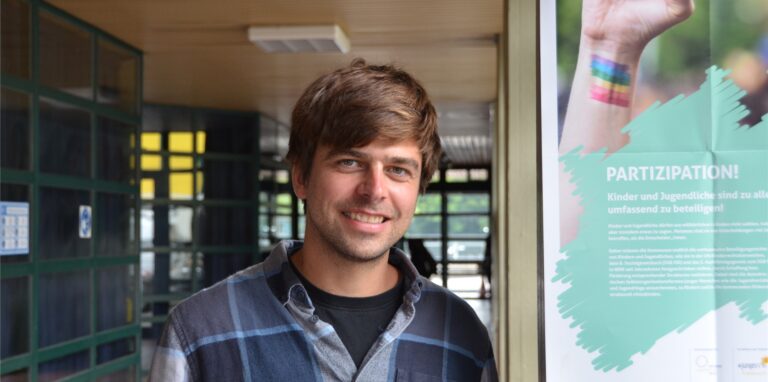 Jochen Pröbsting, Lehrer am Joseph-König-Gymnasium in Haltern, steht neben einem Wahlplakat für die U-18-Bundestagswahl.