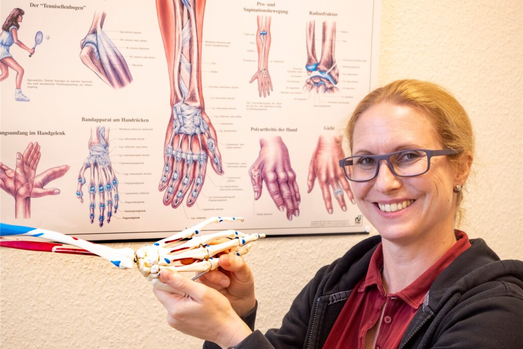 Die Ergotherapeutin Katja Mumme ist auch zertifizierte Hand-Therapeutin und zeigt deshalb die Hand eines Anschauungs-Skeletts.