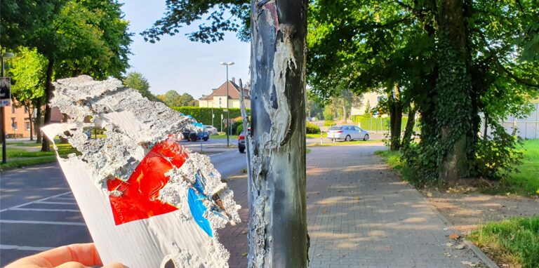 Von dem verbrannten Wahlplakat blieb nur eine Ecke übrig. Der Rest schmolz, der zähflüssige Kunststoff floss an dem Laternenmast herunter und beschädigte diesen.