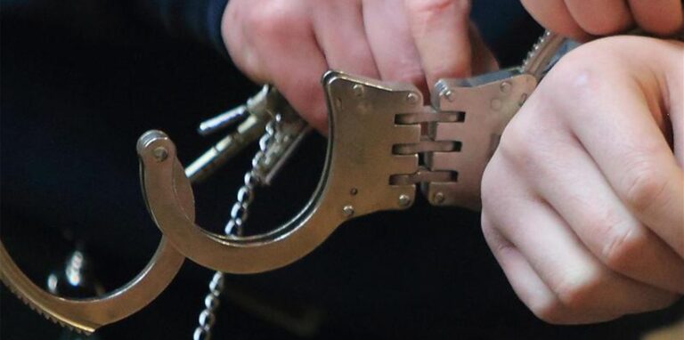 Einer Person werden Handschellen angelegt