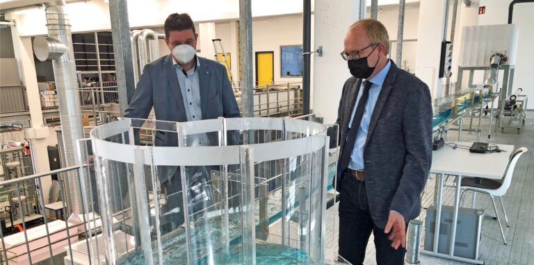Helmut Grüning (r.) demonstriert Bürgermeister Rajko Kravanja die Kraft des Wassers, die ein Kanalnetz überfordern kann.