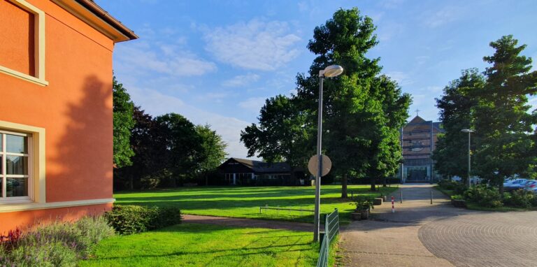 Auf der Wiese zwischen dem Pfarrhaus (links im Bild) und dem Kindergarten St. Marien (im Hintergrund) soll die sogenannte „Rotationskita“ gebaut werden. Hinten rechts im Bild ist die Kirche St. Maria Heimsuchung zu sehen.
