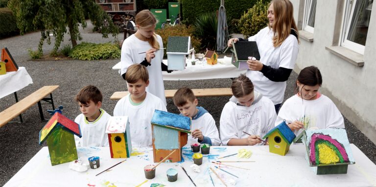Die Kinder im Kleingarten Löntroper Heide bemalten Nistkästen für die Singvögel, v. l.: Adrian, Jadon, Emily, Justin, Mailyn, Lilian und Josephine.