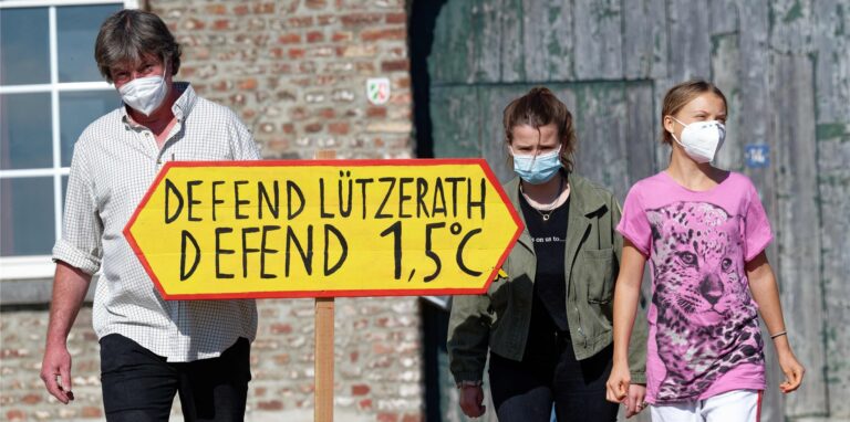 Der letzte Bauer im Tagebaudorf Lützerath, Eckhardt Heukamp (l-r) und die Klimaaktivistinnen Luisa Neubauer und Greta Thunberg kommen mit einem Schild „Defend Lützerath Defend 1.5 Grad C“ zu einem Pressetermin vor dem Hof vom Heukamp.