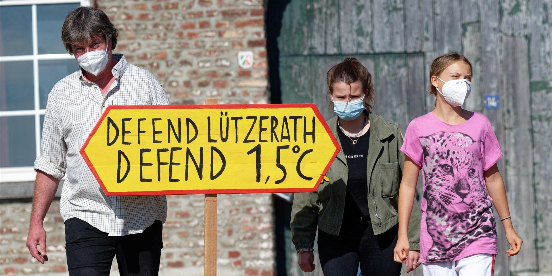 Der letzte Bauer im Tagebaudorf Lützerath, Eckhardt Heukamp (l-r) und die Klimaaktivistinnen Luisa Neubauer und Greta Thunberg kommen mit einem Schild „Defend Lützerath Defend 1.5 Grad C“ zu einem Pressetermin vor dem Hof vom Heukamp.