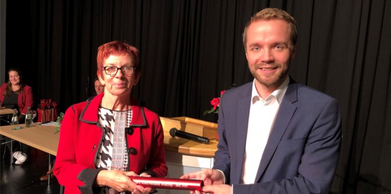 Marcel Mittelbach übergibt den roten Staffelstab an Margit Tigges.