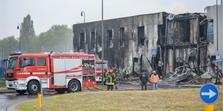Feuerwehrleute stehen an der Unfallstelle, nachdem ein Leichtflugzeug kurz nach dem Start abgestützt und in ein leerstehendes Bürogebäude gekracht ist.