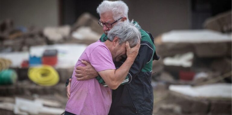 Weinend liegen sich die Brüder Bernd (l) und Gerd Gasper vor ihrem von der Flut zerstörten Elternhaus in Altenahr in den Armen.