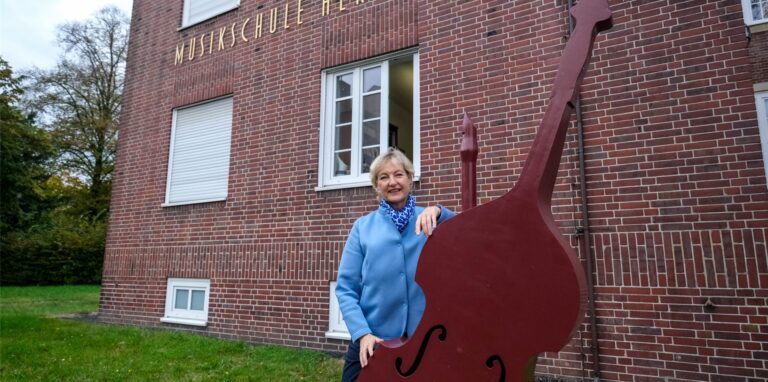 Sabine Fiebig-Fechtner am Riesen-Kontrabass, der die Besucher der Städtischen Musikschule am Eingang empfängt.