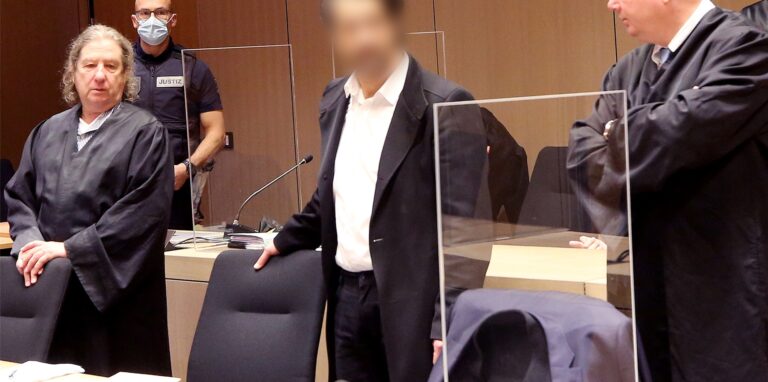 Einer der beiden Angeklagten steht mit seinen Verteidigern im Bochumer Landgericht.